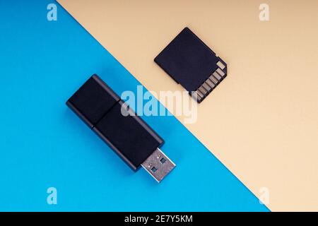 flash usb e scheda di memoria sd su sfondo blu e giallo. diversi tipi di dispositivi di archiviazione portatili. concetto di archiviazione dati Foto Stock