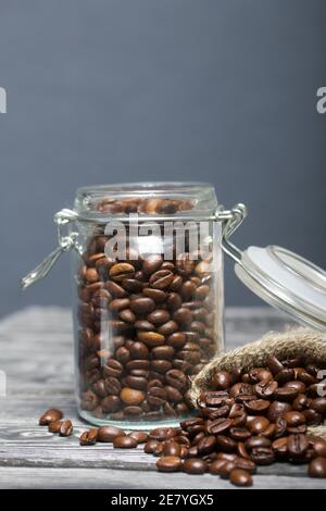 Chicchi di caffè. Versate in un vasetto di borsa di trascinamento e in una borsa di lino. Primo piano. Foto Stock