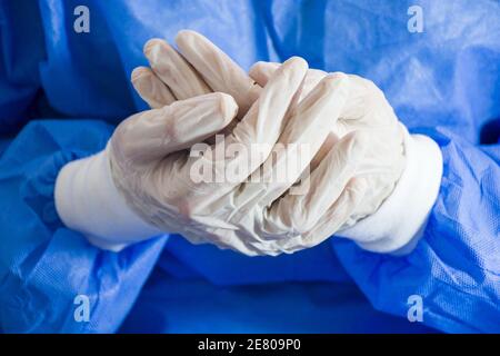 Colpo di closeup delle mani del medico con sterile e disinfezione bianco guanti e uniforme speciale Foto Stock