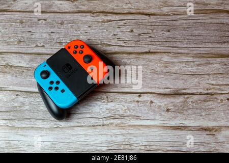Un controller di commutazione Nintendo posto su un tavolo di legno, noto anche come joycons Foto Stock