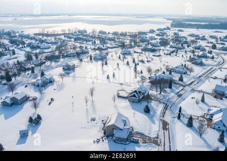 Sorvolando grandi case con grandi cantieri in un quartiere suburbano subito dopo una neve fresca. Foto Stock