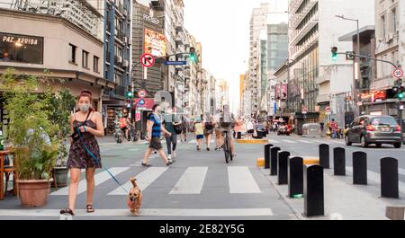 Le persone che indossano maschere facciali camminano lungo Corrientes Avenue a Buenos Aires, Argentina, durante la pandemia del Covid-19 Foto Stock