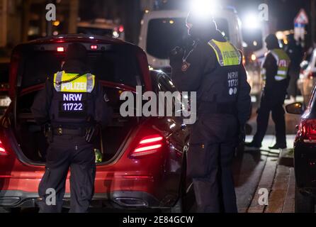 Dortmund, Germania. 30 gennaio 2021. Gli agenti di polizia controllano i veicoli su una strada arteriale. Nella lotta contro la scena illegale di accelerazione e messa a punto, il capo della polizia di Dortmund ha ordinato una cosiddetta caccia strategica. Dortmund, con il bastione intorno al centro della città, è considerata una roccaforte della scena di accelerazione e tuning in Westfalia. Credit: Bernd Thissen/dpa/Alamy Live News Foto Stock