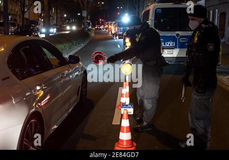 Dortmund, Germania. 30 gennaio 2021. Gli agenti di polizia controllano i veicoli su una strada arteriale. Nella lotta contro la scena illegale di accelerazione e messa a punto, il capo della polizia di Dortmund ha ordinato una cosiddetta caccia strategica. Dortmund, con il bastione intorno al centro della città, è considerata una roccaforte della scena di accelerazione e tuning in Westfalia. Credit: Bernd Thissen/dpa/Alamy Live News Foto Stock