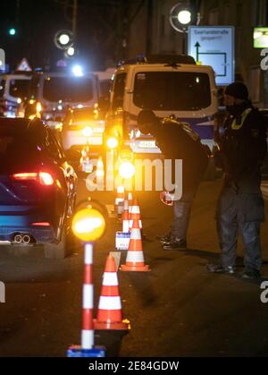 Dortmund, Germania. 30 gennaio 2021. Gli agenti di polizia controllano i veicoli su una strada arteriale. Nella lotta contro la scena illegale di accelerazione e messa a punto, il capo della polizia di Dortmund ha ordinato una cosiddetta caccia strategica. Dortmund, con il bastione intorno al centro della città, è considerata una roccaforte della scena di accelerazione e tuning in Westfalia. Credit: Bernd Thissen/dpa/Alamy Live News Foto Stock