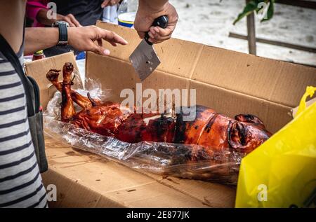 Circa per mangiare il Lechon delizioso (maiale arrosto) mentre in vacanza a Davao City Filippine. È stato un soggiorno meraviglioso in spiaggia. Tritare cibo da mangiare. Foto Stock