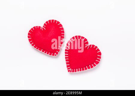 Due cuori tessili rossi su sfondo bianco. Il concetto di San Valentino. Spazio di copia per il testo - immagine Foto Stock