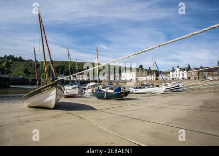 Barche e barche sulla sabbia nel porto di Stonehaven, Aberdeenshire, Scozia, in una giornata di sole con bassa marea Foto Stock