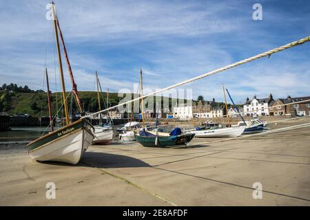 Barche e barche sulla sabbia nel porto di Stonehaven, Aberdeenshire, Scozia, in una giornata di sole con bassa marea Foto Stock