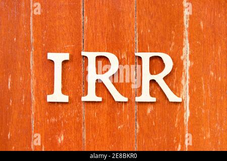 Lettera alfabetica in parola IRR (Abbreviazione del tasso di rendimento interno) su vecchio sfondo di legno di colore rosso Foto Stock