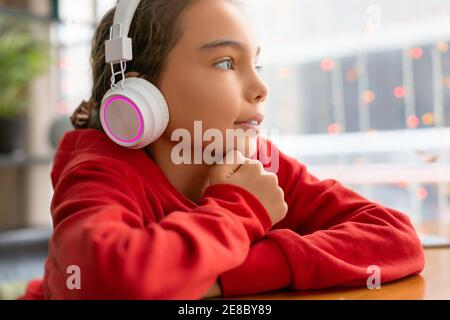 Ragazza adolescente che ascolta la musica con le cuffie. Concetto di tecnologia moderna. Foto Stock