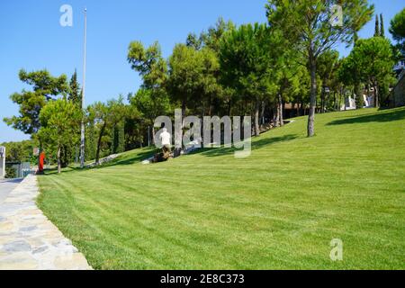 L'uomo sta tenendo un tubo dell'acqua e innaffiare il giardino. Lavori sulla casa e l'orto, cura del territorio. Foto di alta qualità Foto Stock