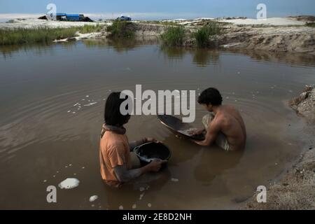 I minatori d'oro che ansimano l'oro su uno stagno in una piccola area di estrazione dell'oro a Hampalit, nella reggenza di Katingan, nella provincia di Kalimantan centrale, Indonesia. Foto Stock