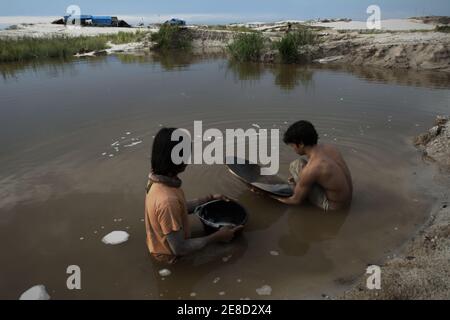 I minatori d'oro che ansimano l'oro su uno stagno in una piccola area di estrazione dell'oro a Hampalit, nella reggenza di Katingan, nella provincia di Kalimantan centrale, Indonesia. Foto Stock