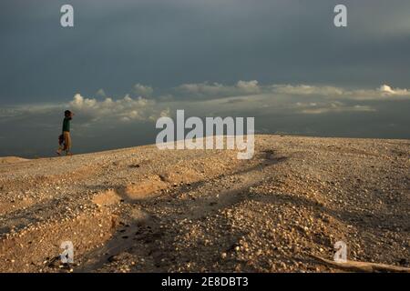 Un minatore d'oro che cammina sul paesaggio sabbioso della piccola area di estrazione dell'oro in Hampalit, la regency di Katingan, la provincia di Kalimantan centrale, Indonesia. Foto Stock