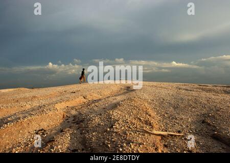 Un minatore d'oro che cammina sul paesaggio sabbioso della piccola area di estrazione dell'oro a Hampalit, nella reggenza di Katingan, nella provincia centrale di Kalimantan, in Indonesia. © Reynold Sumayku Foto Stock