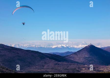 Parapendio volare da solo sopra Panorama intorno a Sveta gora. Alpi Karniche e Dolomiti sullo sfondo. Foto Stock