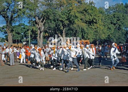 Uomini in costume al carnevale della Martinica, Fort de France nei Caraibi, febbraio 1959. In Martinica festeggiamenti di carnevale durano quattro giorni che iniziano la prima Domenica dopo l'Epifania. Il ‘vidé’ o sfilata di Carnevale occupa le strade di Fort de France. Il carnevale è anche un'occasione per mostrare la cultura dell'isola con costumi e maschere tradizionali. Qui gli uomini in una ‘gang’ indossano maschere ‘monkey’ e cappelli di paglia. Foto Stock