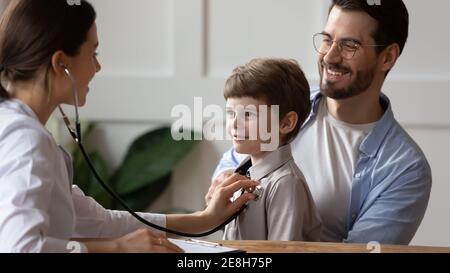 Medico femminile ascoltare il cuore paziente del bambino Foto Stock