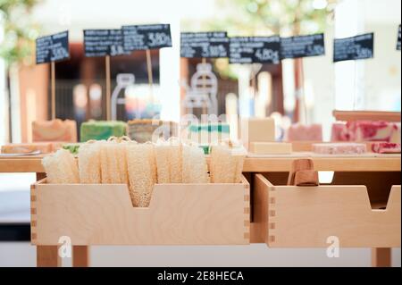 Sapone colorato fatto a mano con pinze e etichette di prezzo su tavolo di legno in eco-store Foto Stock