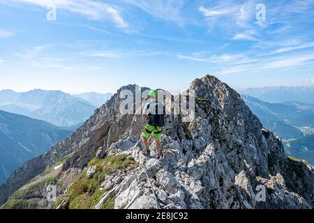 Alpinista su una cresta su una via fissa sicura di corda, Mittenwalder Hoehenweg, Karwendel Montagne, Mittenwald, Baviera, Germania Foto Stock