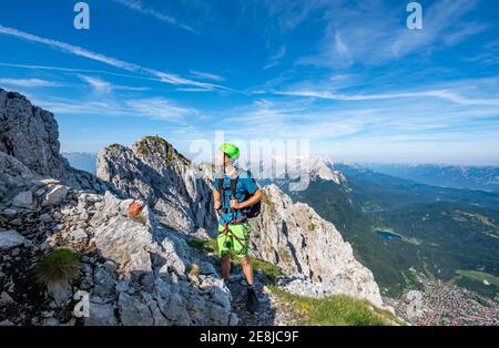 L'alpinista si arrampica su una via fissa sicura, Mittenwalder Hoehenweg, vista di Mittenwald, Karwendel Mountains, Mittenwald, Baviera, Germania Foto Stock