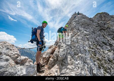 Alpinista su una cresta su una via fissa sicura di corda, Mittenwalder Hoehenweg, Karwendel Montagne, Mittenwald, Baviera, Germania Foto Stock