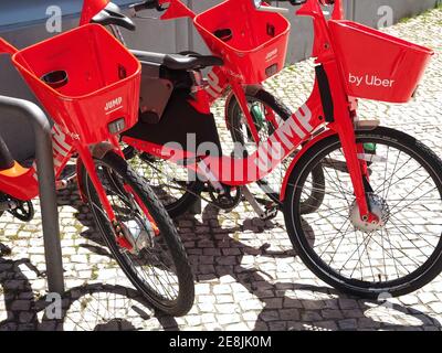 Salta le bici elettriche Uber rosse da noleggiare su una strada Foto Stock