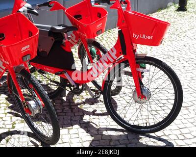 Salta le bici elettriche Uber rosse da noleggiare su una strada Foto Stock