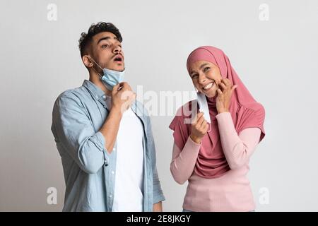 L'uomo musulmano e la donna sentono disagio dopo aver indossato un medico protettivo maschera facciale Foto Stock