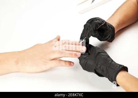 manicurista durante il lavoro con il bastone di metallo del chiodo. un processo di manicure dell'uomo. una persona caucasica irriconoscibile che fa il servizio del chiodo al salone di cure estetiche. Foto Stock