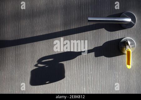 chiave della portiera con etichetta e silhouette sopra porta Foto Stock