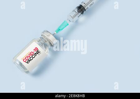 Chiuso di siringa e vaccino covid-19 su sfondo blu, medico concetto di attrezzatura Foto Stock