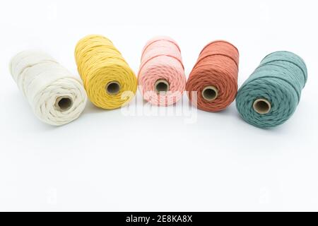 Vista ravvicinata dei colorati cavi in cotone a trefolo singolo per artigianato fai da te in macrame su sfondo bianco. Foto Stock