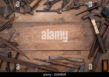 Collezione di antichi utensili a mano per la lavorazione del legno su un banco di lavoro grezzo vecchio legno con spazio vuoto per la copia Foto Stock