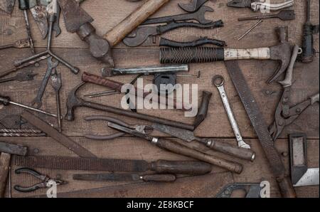 Collezione di antichi utensili a mano per la lavorazione del legno su un banco di lavoro grezzo vecchio legno Foto Stock