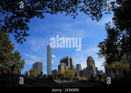 vista dei grattacieli e delle persone sulle rocce dal parco centrale incorniciato da alberi Foto Stock