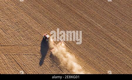 Vista aerea del drone di un trattore che dissoda il terreno Foto Stock