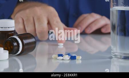 Primo piano immagine con le mani malate che assumono farmaci. Trattamento medico con pillole. Foto Stock