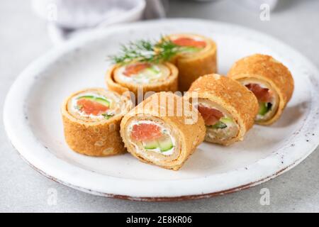 Involtini di salmone crespato con formaggio cremoso erbaced. Antipasto party food Foto Stock