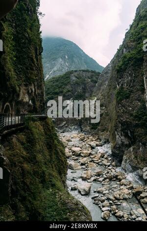 Letto di fiume sassoso con ripide scogliere su ogni lato nel Parco Nazionale di Taroko a Hualien, Taiwan. Foto Stock