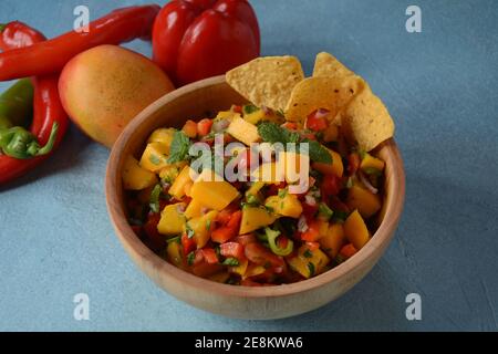 Salsa con mango, erbe, cipolle e peperoni, patatine di mais da vicino in una ciotola. Cibo messicano. Foto Stock