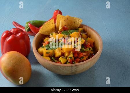 Salsa con mango, erbe, cipolle e peperoni, patatine di mais da vicino in una ciotola. Cibo messicano. Foto Stock