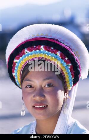 Asia, Cina, Yunnan, Città di Dali, ritratto di sorridente ragazza vestita in tradizionale colorato costume etnico minoritario Bai Foto Stock