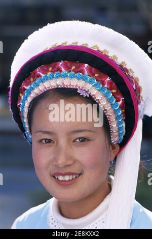 Asia, Cina, Yunnan, Città di Dali, ritratto di sorridente ragazza vestita in tradizionale colorato costume etnico minoritario Bai Foto Stock