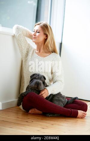 Bella donna bionda sedette con il suo cane Foto Stock
