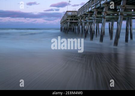 Il molo di pesca di Sandbridge a Virginia Beach al tramonto, con una lunga esposizione che rende l'acqua setosa e sognante Foto Stock