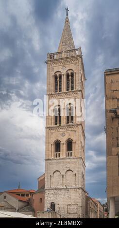 Alto campanile di una chiesa di San Donata in prima architettura romanica nel centro storico di Zara, Croazia. Cielo drammatico e tempestoso Foto Stock