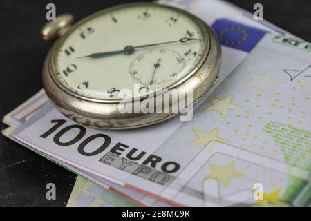 Il tempo è denaro. Pocket Watch e soldi. Foto Stock