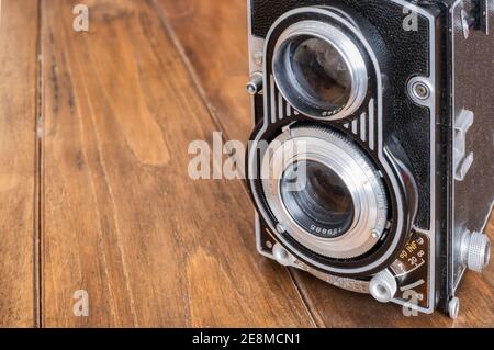 dettaglio degli obiettivi di una fotocamera reflex a doppia lente d'epoca, su un tavolo di legno, fotografia antica e classica, copy space, orizzontale Foto Stock
